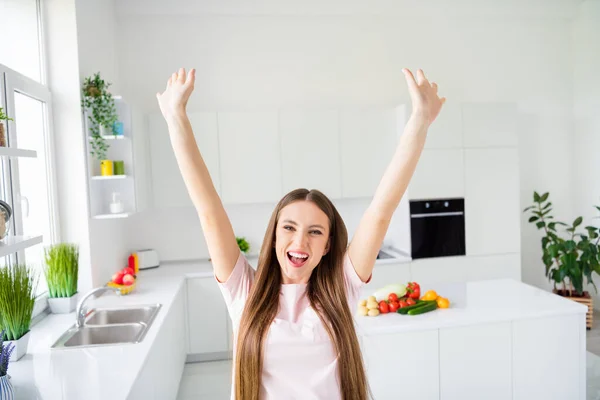 Портрет привлекательной счастливой веселой веселой длинноволосой девушки, готовящей ужин дома, светлый белый дом на кухне в помещении — стоковое фото