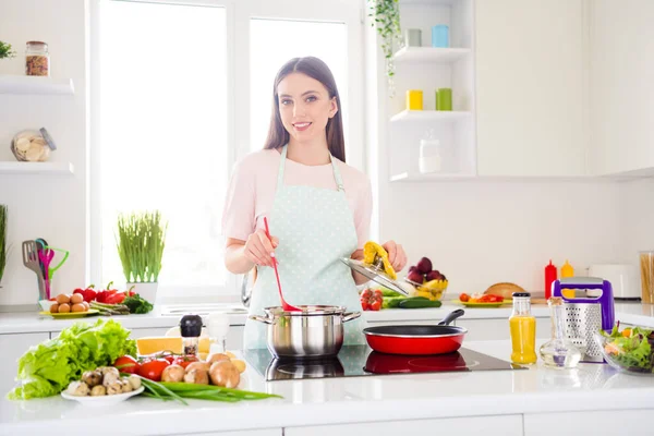 Foto portret jonge vrouw koken soep koken diner in de keuken — Stockfoto