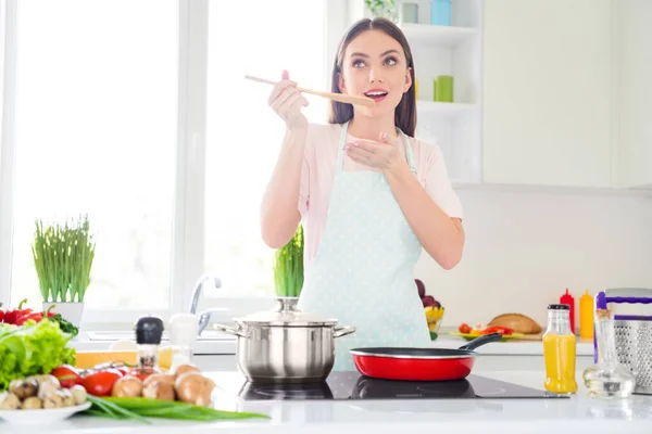 Retrato de atractiva chica de ensueño alegre preparando la cena de pérdida de peso degustación deliciosa comida en casa cocina blanca clara en el interior — Foto de Stock