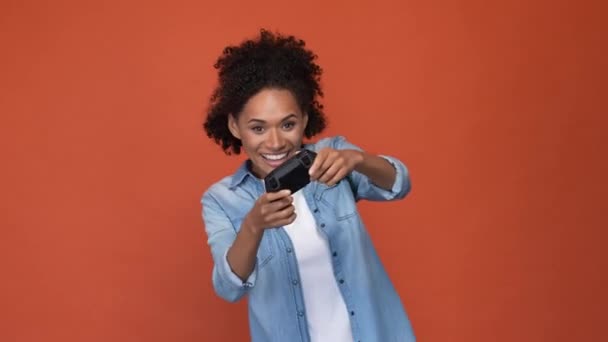 Folle dame jouer jeu vidéo poing jusqu'à isolé brique couleur fond — Video