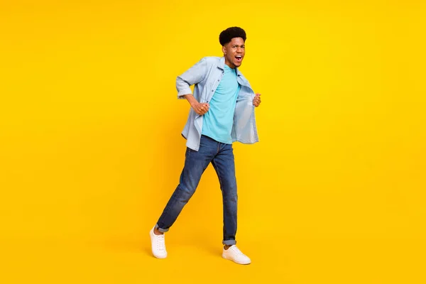 Photo of funny cool dark skin guy dressed denim shirt walking dancing singing isolated yellow color background — Fotografia de Stock