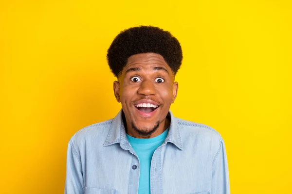 Photo of impressed funky dark skin guy dressed denim shirt smiling open mouth big eyes isolated yellow color background — 图库照片