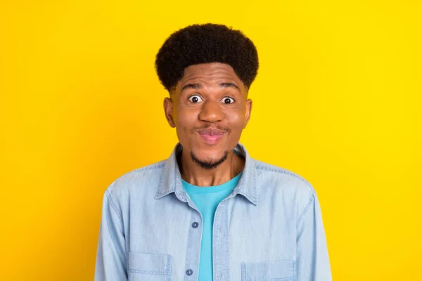 Photo of shocked impressed dark skin guy dressed denim shirt smiling big eyes isolated yellow color background — 图库照片