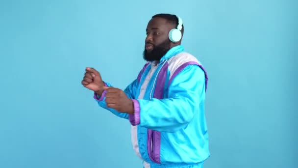 Jeune gars écouter chanson casque rythme danse isolé bleu couleur fond — Video