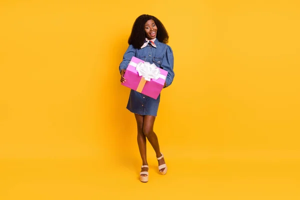 Foto de tamaño completo de feliz alegre emocionado sonriente chica afro encantadora darle regalo de cumpleaños aislado en el fondo de color amarillo — Foto de Stock