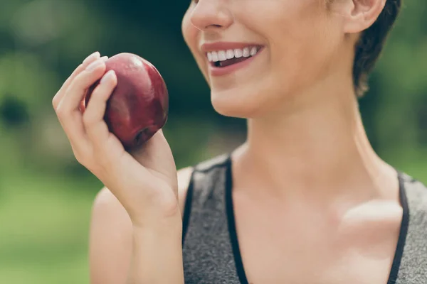 Cropped photo of positive pretty sportswoman eat natural apple wear grey top nature park garden outdoors — Stock Photo, Image