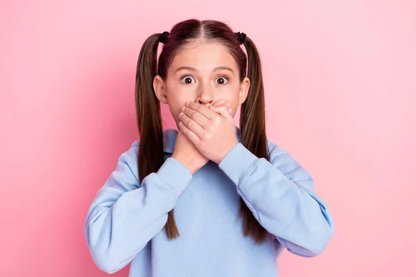 Фотографічний портрет здивованої школярки закрив рот здивований, тримаючи таємницю ізольованою на пастельному рожевому фоні — стокове фото