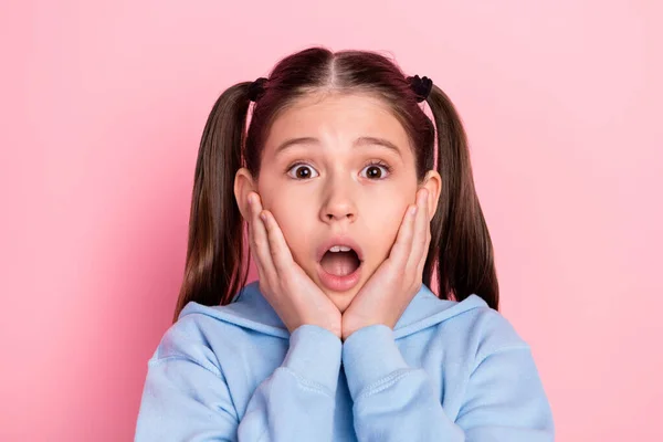 Retrato fotográfico de una colegiala sorprendida mirando fijamente la boca abierta tocando mejillas aisladas sobre fondo de color rosa pastel —  Fotos de Stock