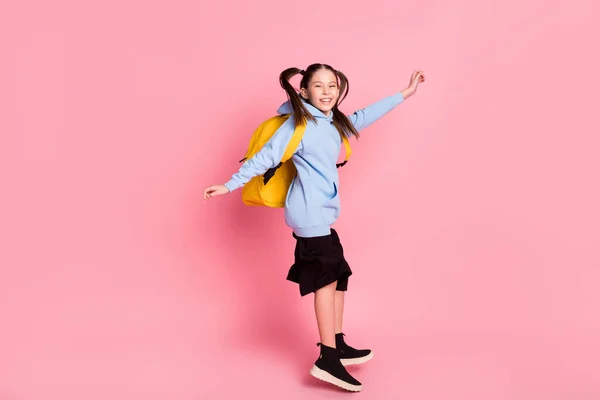 Профиль фигуры в полный рост боковой вид симпатичной веселой трехлетней девочки, прыгающей весело на розовом цветном фоне — стоковое фото