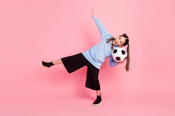 Full length body size photo of schoolgirl in sport outfit keeping ball overjoyed isolated pastel pink color background — Stockfoto