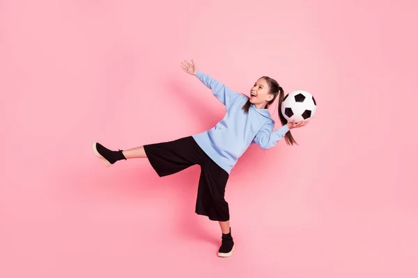 Full length body size photo of schoolgirl in sport outfit throwing ball laughing isolated pastel pink color background — Foto Stock