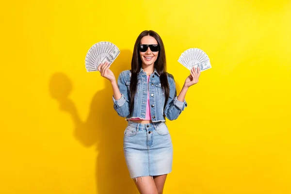 Mutlu, hoş, çekici bir kadının fotoğrafı güneş gözlüğü takıyor. Para sarı arka planda izole edilmiş. — Stok fotoğraf