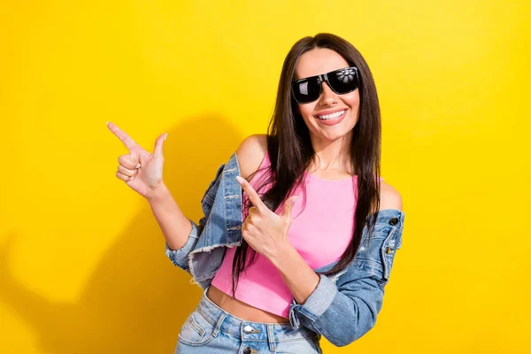 Foto de encantadora joven alegre sonrisa dedo dedo vacío espacio venta aislado sobre fondo de color amarillo — Foto de Stock