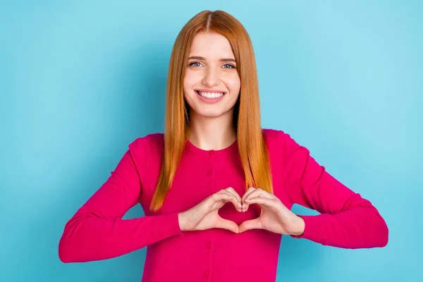 Portrait d'une jolie fille aux cheveux roux joyeux montrant le symbole du cœur soins de santé isolés sur fond de couleur bleu vif — Photo