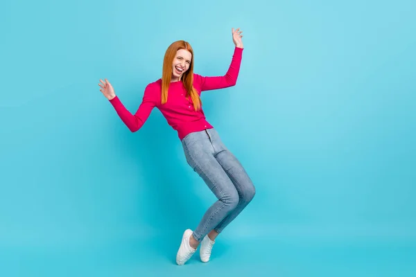 フルサイズ写真の若い喜び生姜頭の女性のダンスは、ピンクのセータージーンズを身に着けている鮮やかな青の色の背景に隔離 — ストック写真