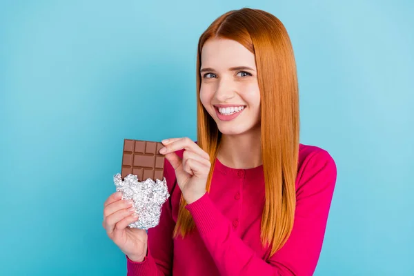 Portret van aantrekkelijke vrolijke meisje eten smakelijke melk choco bar plaat liefde geïsoleerd over levendige blauwe kleur achtergrond — Stockfoto