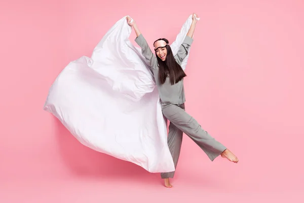 Foto de larga duración de dulce dama encantadora ropa de dormir máscara sosteniendo manta voladora caminando sonriendo aislado color rosa fondo — Foto de Stock