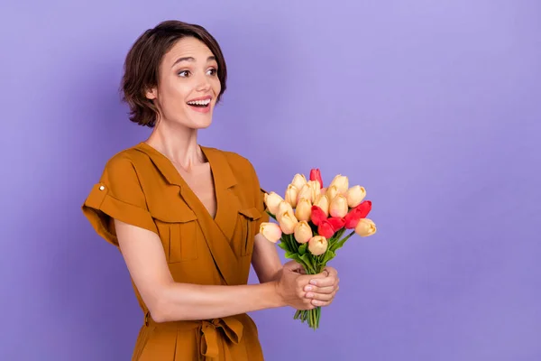 Profiel zijkant foto van jonge opgewonden vrouw gelukkig positieve glimlach geven bloemen cadeau geïsoleerd over paarse kleur achtergrond — Stockfoto