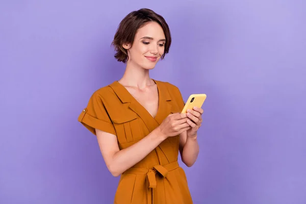 若い魅力的な女性の写真幸せな正の笑顔チャットタイプの携帯電話は紫の色の背景に隔離 — ストック写真