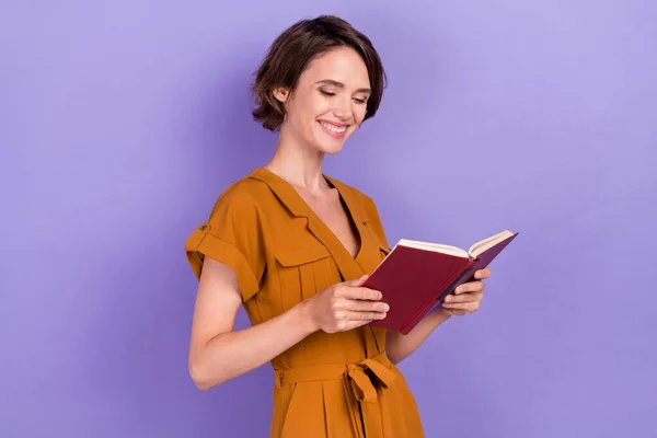 Foto de feliz mujer joven positiva cogida de la mano lector de libros buen humor sonrisa aislada sobre fondo de color púrpura —  Fotos de Stock