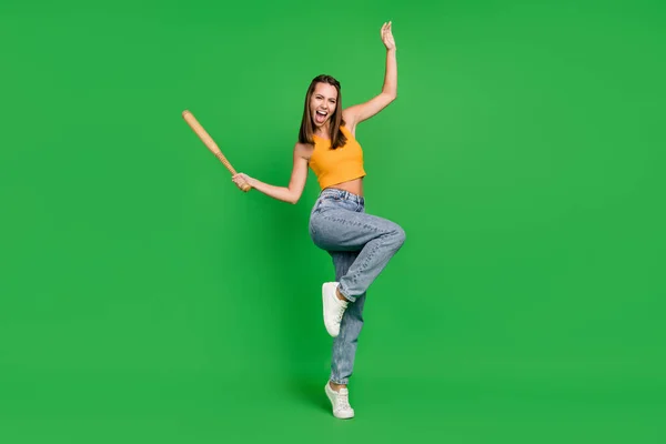 Fotografie celého těla mladé legrační brunetky dáma držet bit nosit top džíny boty izolované na zeleném pozadí — Stock fotografie