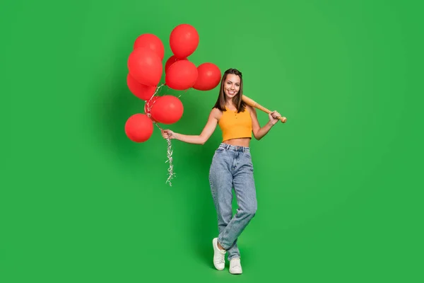 Full size photo of millennial nice brunette lady hold bit balloons wear top jeans shoes isolated on green background — Stockfoto