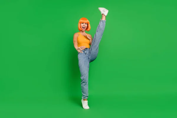 Foto de cuerpo completo de mujer joven loca positiva levantar la pierna de combate de combate fresco aislado en el fondo de color verde — Foto de Stock