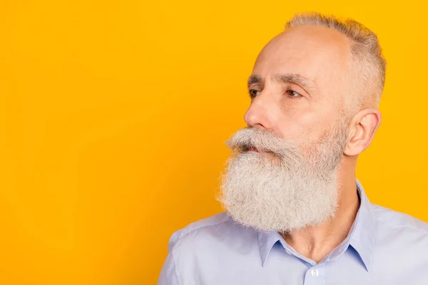 Profile photo of strict beard aged man look empty space wear blue shirt isolated on yellow color background — стоковое фото