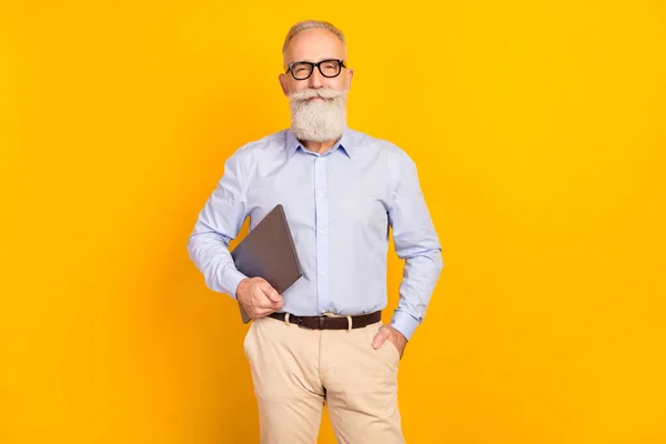 Photo of cheerful happy old man hold laptop good mood pocket isolated on shine yellow color background — Fotografia de Stock