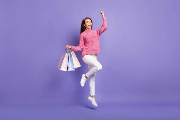 クレイジー女性ジャンプホールド店パッケージの写真空のスペースはピンクのプルオーバーパンツの靴を着用見て孤立紫色の背景 — ストック写真