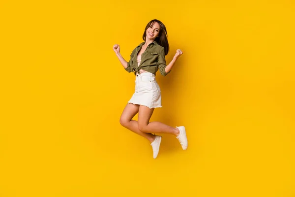 フル長さプロフィール写真の喜び陽気な女の子ジャンプ拳アップお祝いの黄色の色の背景に孤立 — ストック写真