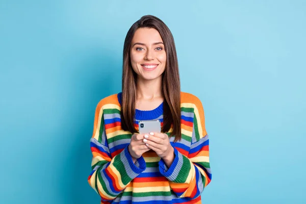 Φωτογραφία πορτρέτο του κοριτσιού χρησιμοποιώντας την εφαρμογή στο κινητό τηλέφωνο περιήγηση στο διαδίκτυο χαμογελώντας απομονωμένο σε ζωντανό φόντο μπλε χρώμα — Φωτογραφία Αρχείου