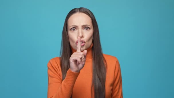 女性の指の口は静かな隔離された青の背景を保つ — ストック動画