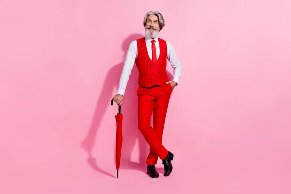 Volledige lichaamsomvang uitzicht van aantrekkelijke vrolijke minded grijs-harige man met parasol denken geïsoleerd over roze pastel kleur achtergrond — Stockfoto