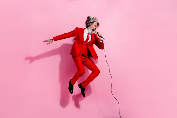 Volledige lichaamsomvang uitzicht van aantrekkelijke gekke grijs-harige man zingen springen hit rots geïsoleerd over roze pastel kleur achtergrond — Stockfoto