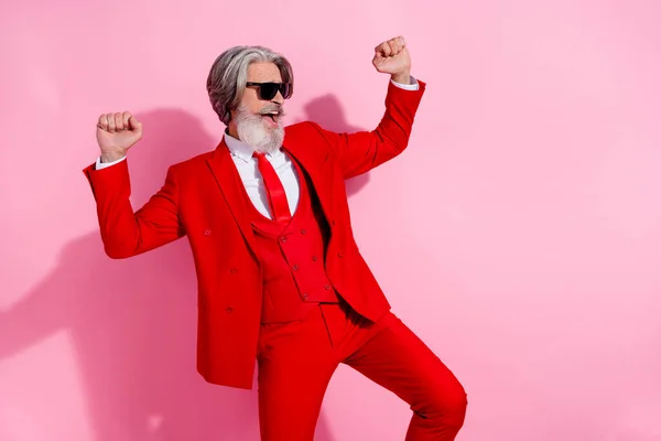 Foto van vrij gelukkig man gepensioneerde gekleed rode jas dansen rijzende vuisten lege ruimte geïsoleerde roze kleur achtergrond — Stockfoto