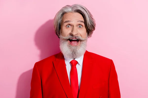 Komik, emekli bir adamın fotoğrafı kırmızı takım elbise giyiyor. Gülümsüyor. Ağzı açık, izole pembe arka plan. — Stok fotoğraf