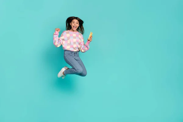 Full length body size view of beautiful trendy lucky funny girl jumping using cell rejoice isolated on shine teal turquoise color background — Stock Photo, Image