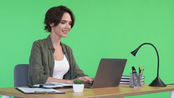 スマートCEO女性は、ネットブックプロジェクト孤立緑の色の背景を使用してテーブルに座る — ストック動画