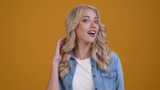Жінка торкається хвилястого волосся насолоджуватися оздоровчою терапією ізольований блискучий кольоровий фон — стокове відео