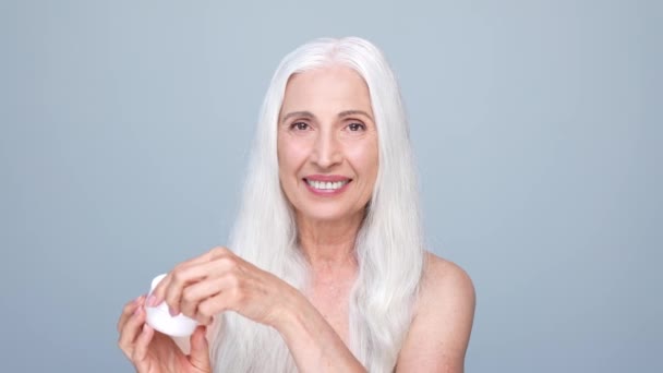 Retired pensioner lady present mask gel isolated pastel color background — Vídeo de Stock