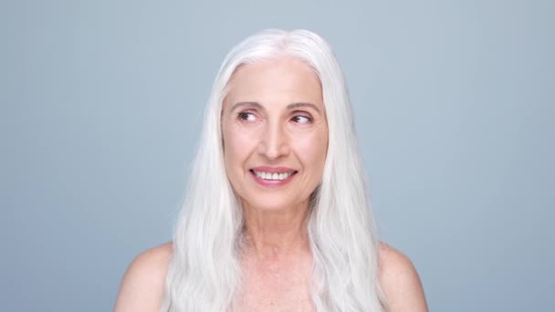 Ηλικιωμένη κυρία χαμογελαστή ματιά κενό χώρο απομονωμένο παστέλ χρώμα φόντο — Αρχείο Βίντεο