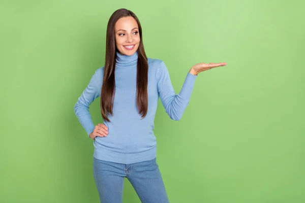 Photo of inspired smart lady hold empty space pick best option wear blue turtleneck isolated green color background — Fotografia de Stock