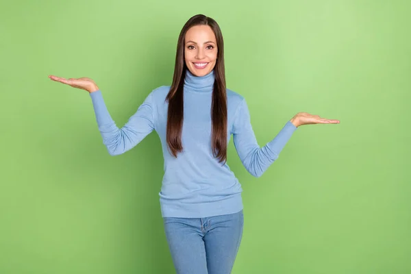 Photo of confident lady palms demonstrate empty space novelty wear blue turtleneck isolated green color background — Foto Stock