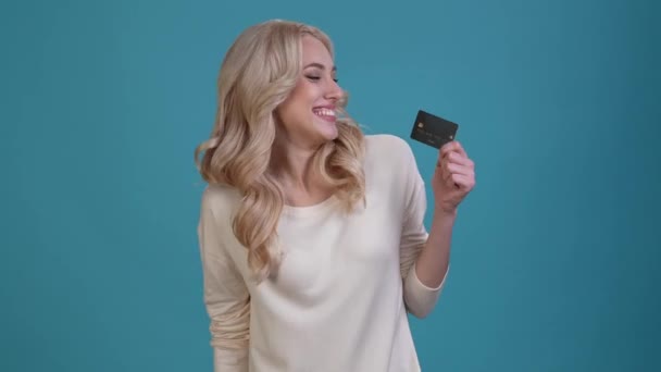 Excited lady hold debit card fist up isolated blue color background — Vídeo de Stock