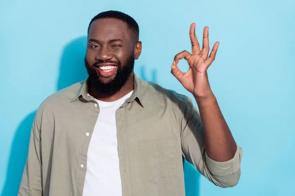 Photo of young cheerful african guy wink eye promoter approve good ads isolated over blue color background — Stock fotografie