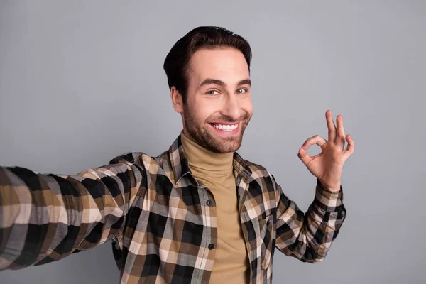 Photo of charming cute man wear plaid shirt showing okey recording self video isolated grey color background — Fotografia de Stock