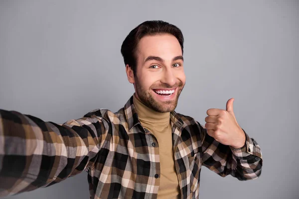 Self-portrait of attractive glad cheerful guy wearing checked shirt showing thumbup ad cool isolated over grey color background — Fotografia de Stock