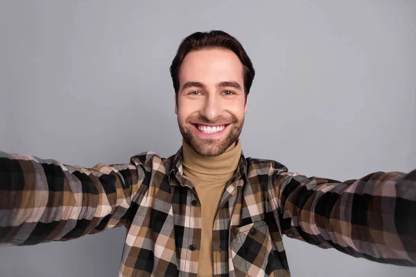 Photo of charming pretty man wear plaid shirt smiling recording self video isolated grey color background — Stockfoto