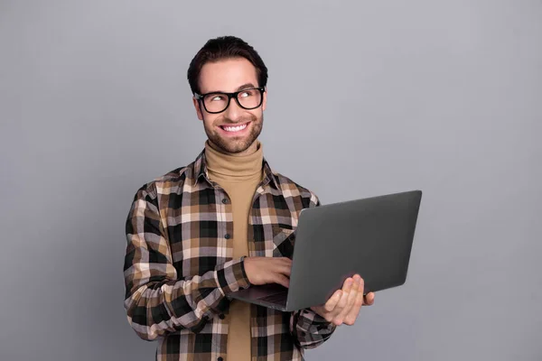 Portret atrakcyjnego, wesołego, wyszkolonego eksperta używającego laptopa myślącego o przestrzeni odizolowanej od szarego tła — Zdjęcie stockowe